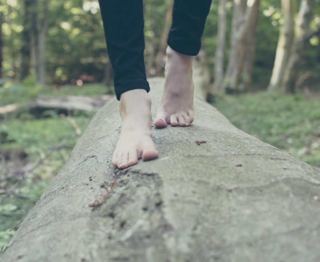 A woman with flat feet walking on a tree
