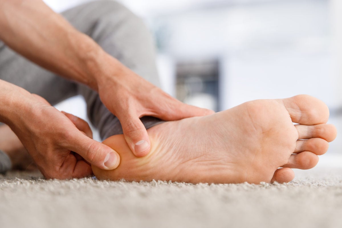Man rubbing his foot suffering from plantar fasciitis